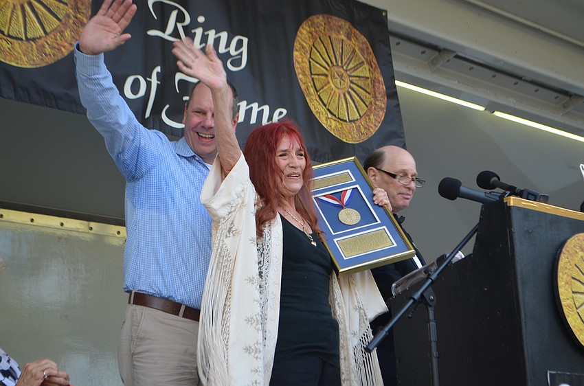 Dagmar Mootz-Beavers, with her cousin Andreas Funk, waves to the crowd after speaking about her time in the circus.