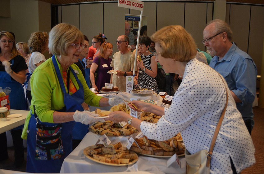Irene Hyman hands Barbara Chertok a plate of baked goods. All the baked goods and other food offered at the festival were made by members of Temple Sinai.