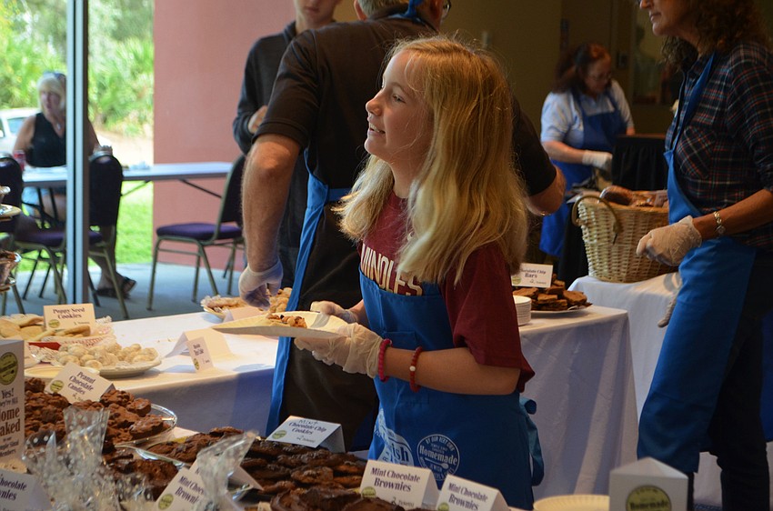 Katie Armstrong, 11, helps hand out baked goods at the festival.