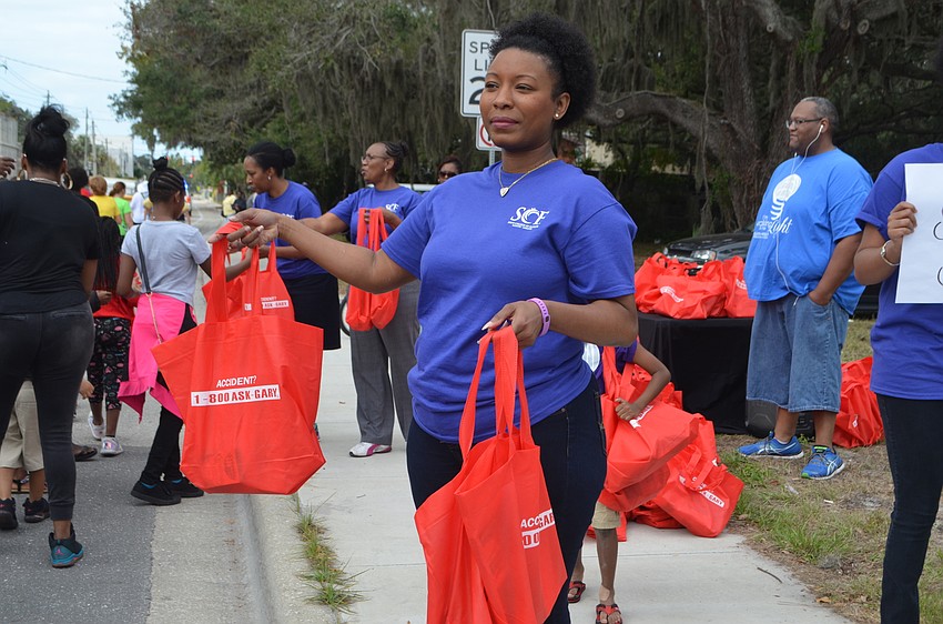 Shavonne Simon, part of I Am More, Inc., hands out school supplies to kids walking in the march.