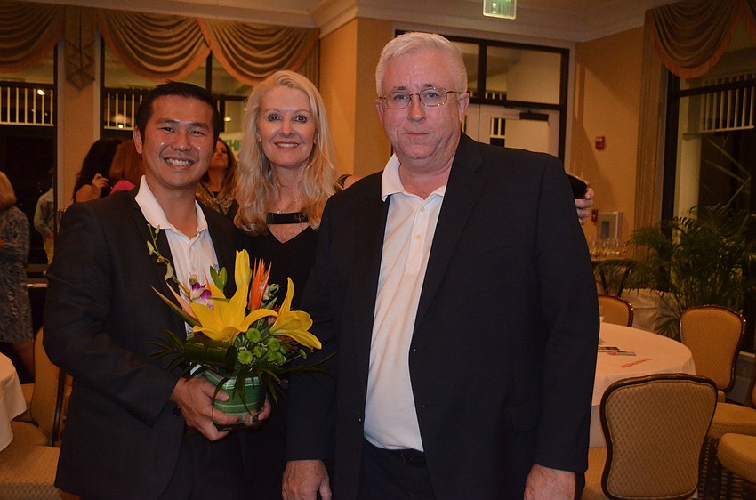 Event sponsors Eric Teoh and Michael Renick of Michael J. Renick and Company with club President Susan Phillips. Renick announced that for every house his company closes on in 2017, he will donate $1,000 to the garden club and its