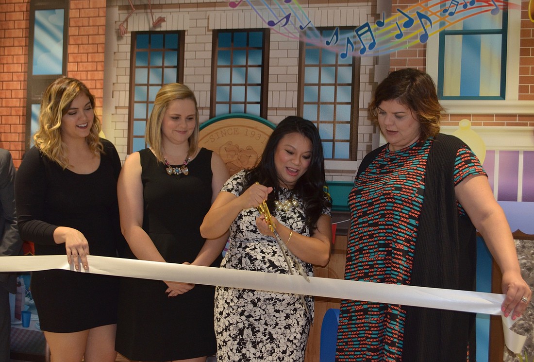 Savanna King, Cassidy Gilley, Dr. LoanAnh Bui and Morgan Merritt cut the ribbon during the grand opening of Little Town Smiles.