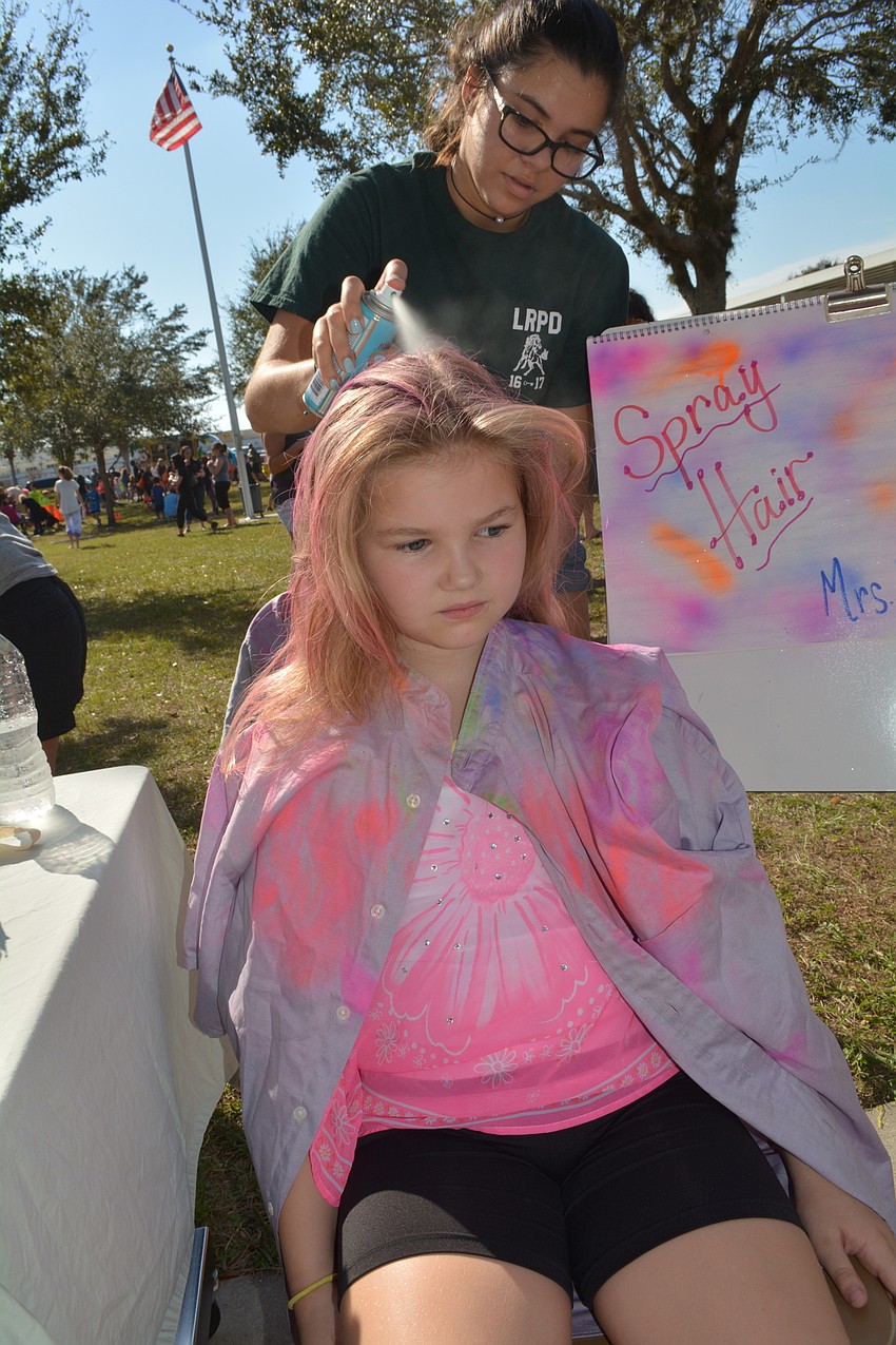 Lakewood Ranch High School'    s Carol Bado paints Britney Peterson'    s hair pink, purple and blue. She added a little glitter, too.