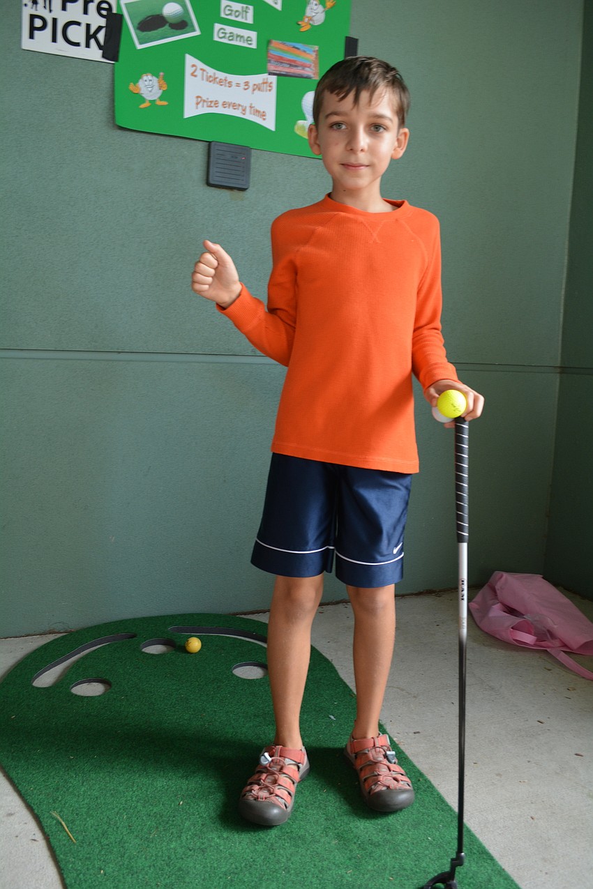 Lucas Wingert, 11, promotes three putts for two tickets to passersby of Jeannine Germer'    s fifth-grade class.