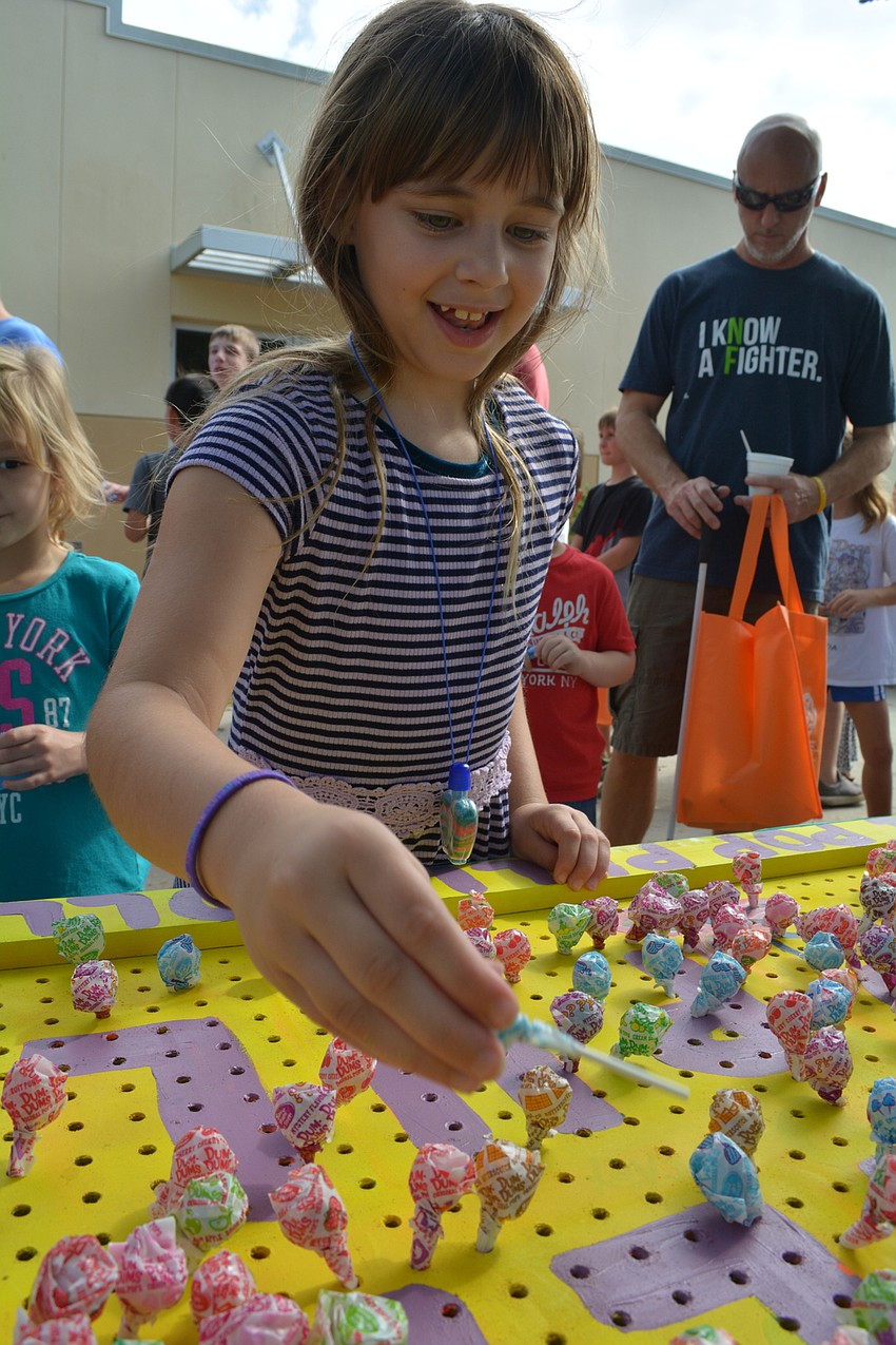 Liz Bentze, 8, likes the lollipop pull game. She won a figurine of 