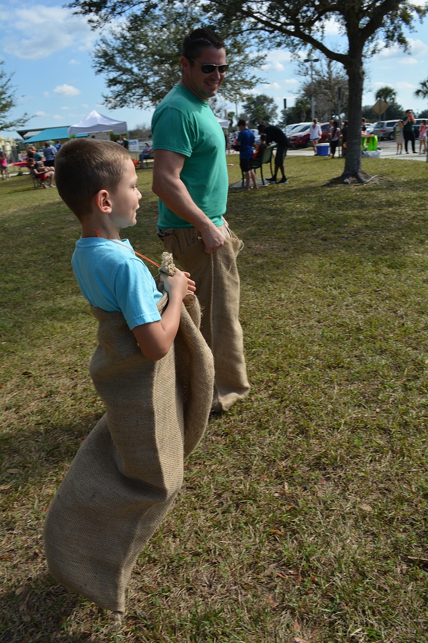 Christian Pereira, 6, edges past his dad, Chris, in the last moments of their potato sack race.