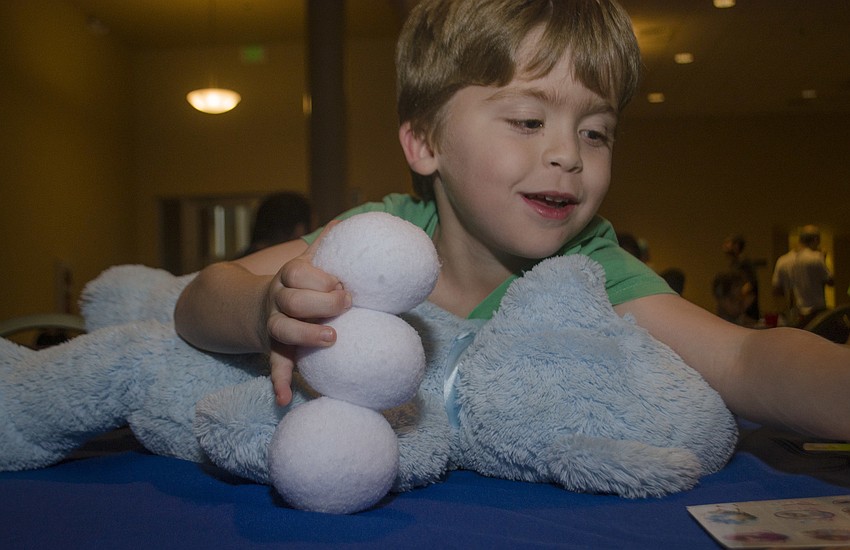 Skate Segal makes a snowman out of cloth “snowballs.”