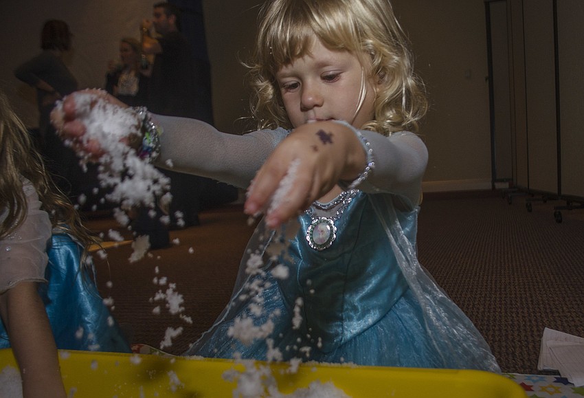 Raina Kurnov plays with fake snow.