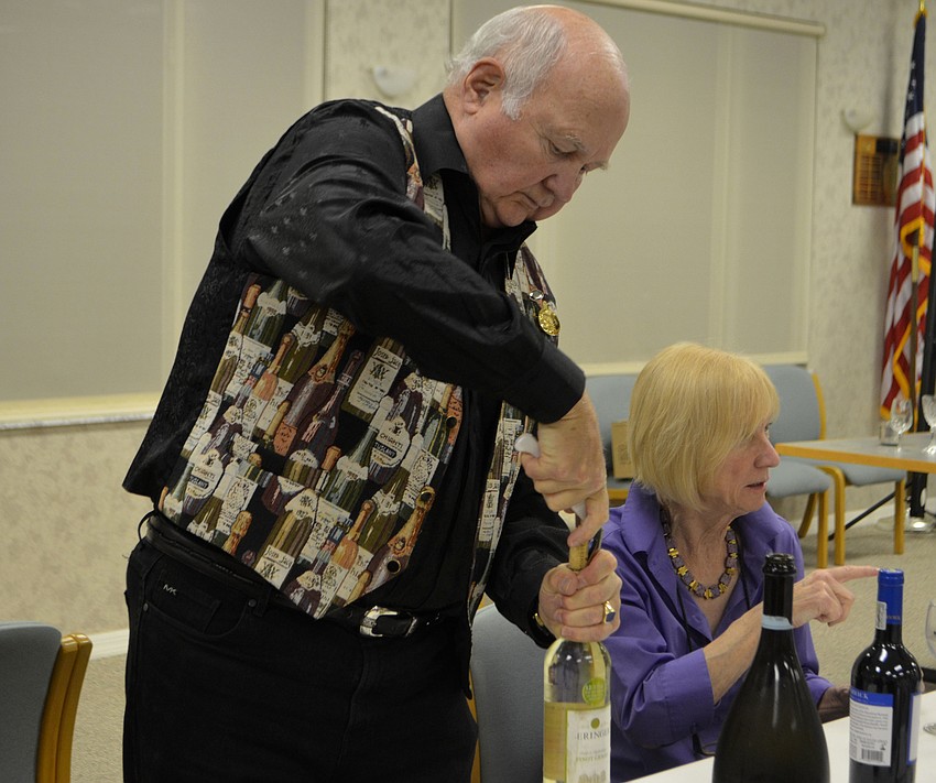 George Muller opens a bottle of wine for attendees at the garden club’s 
January meeting.