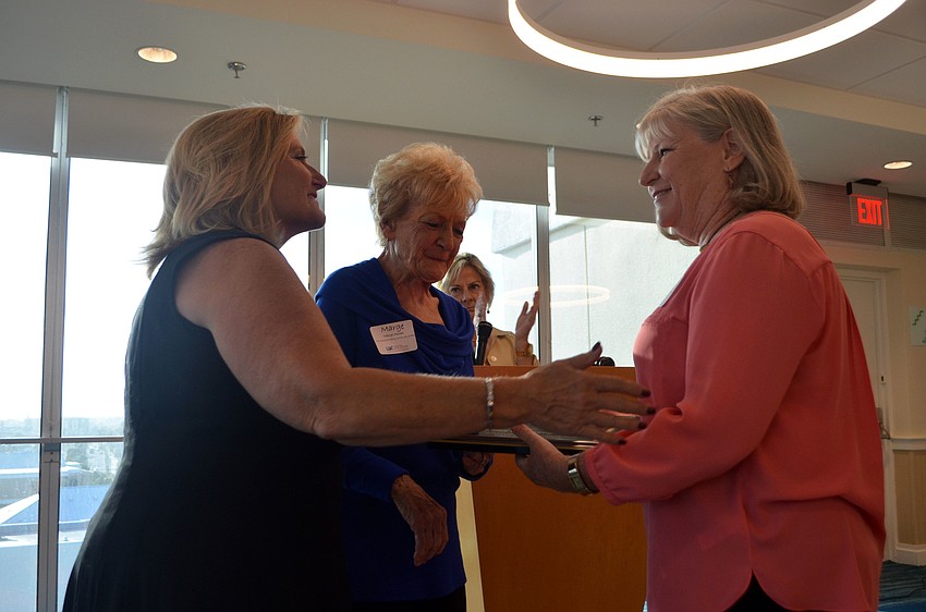 Carol Erker accepts the “Ed Moran Memorial Award” from Moran’s daughter and wife, Jan Jordan and Marge Moran.