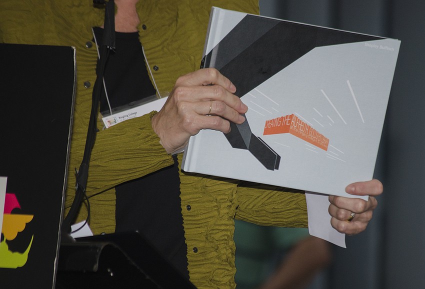 Angela Watson, who was one of the primary architects on the project, holds a book documenting the construction and design of the Alfred R. Goldstein Library.