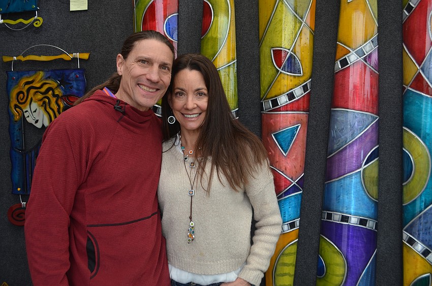 Marc and Kristin DeSantis stand with some of Kristin Desantis’ work. She specializes in contemporary metal.