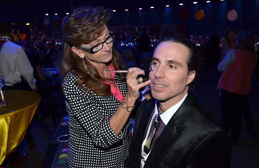 Amy Kaiser paints Octavio Martin’s face.