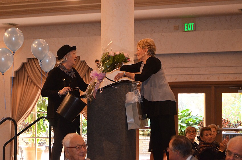 Nancy Cohen gives Sylvia Pastor a bouquet of flowers after thanking her for all of her hard work. The two were co-chairwomen of the fashion show.