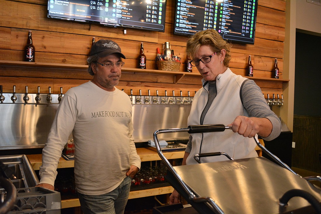 Mark Caragiulo helps Craft Growlers to Go owner Jeanne Dooley work through kitchen logistics.