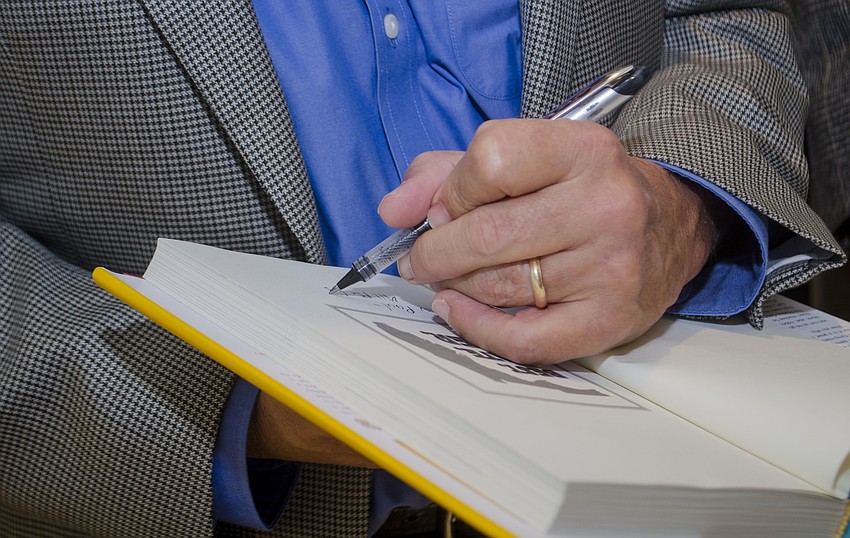 Dave Barry signs a copy of his book 