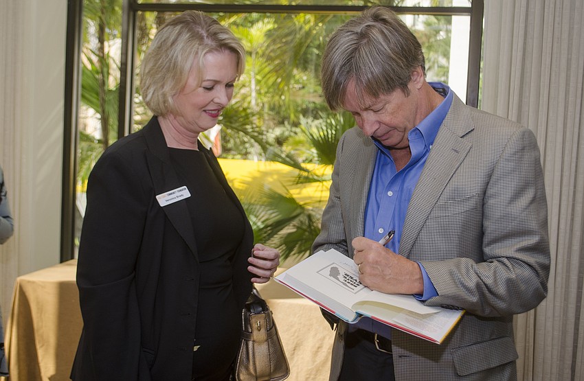 Veronica Brady gets a copy of Barry'     s book signed during the meet and greet prior to the luncheon.