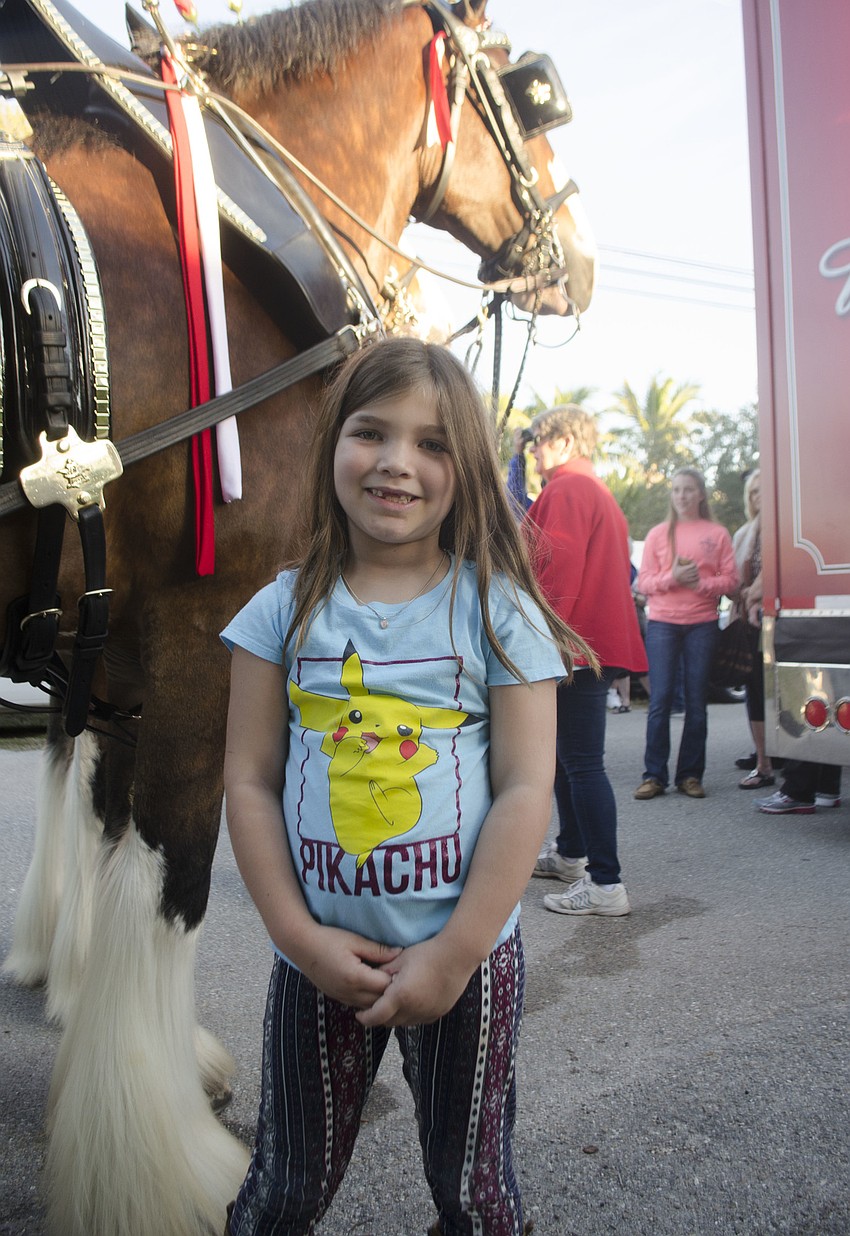 Makenzie Poppa stands next to the Budweiser Clydesdales before they began their parade down Ocean Boulevard.