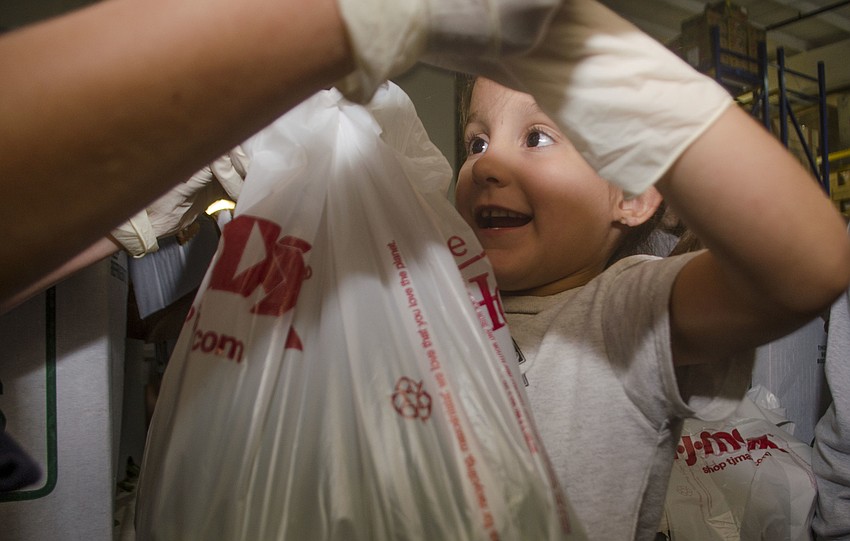 St. Mary student Sophia Antico helps her St. Martha buddy Addyson Rudd tie a bag of green beans that they sorted.