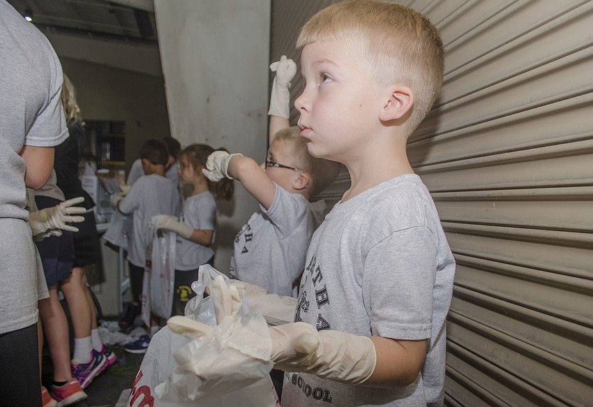 Christian Valentine holds a bag open while his buddy Nicolas Bencomo sorts green beans.