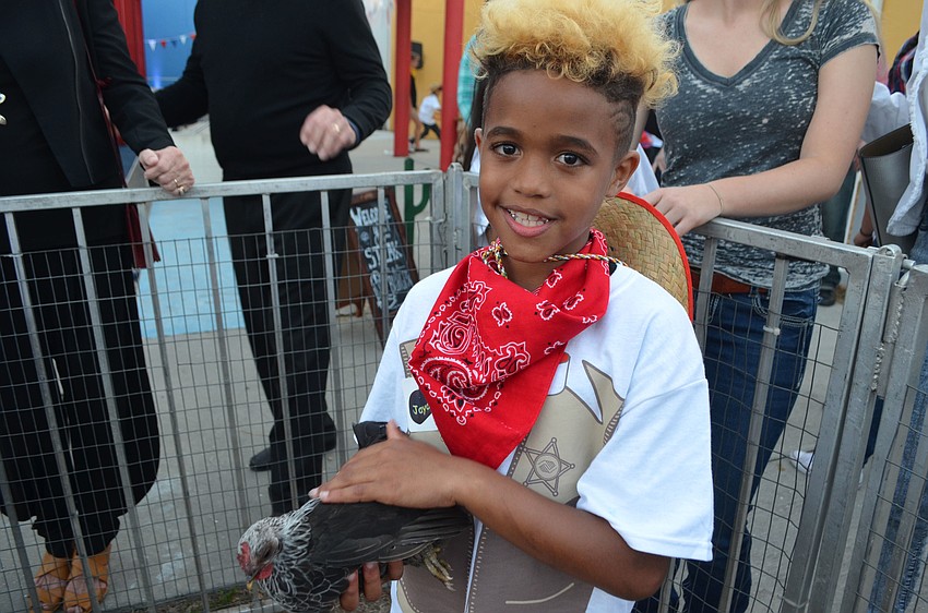 Jayden R. pets one of several chickens at the petting zoo.