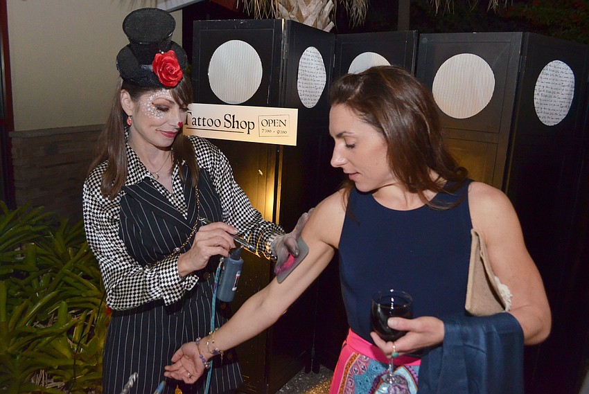 Makeup artist Suzy Kalin gives Leigh Nordman an airbrush tattoo.