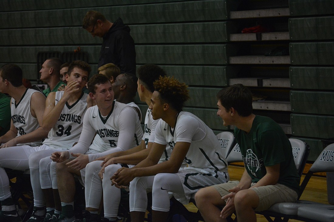 The Mustangs laugh with each other on the bench.