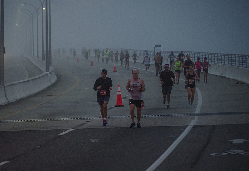 Runners run across the Ringling Bridge.