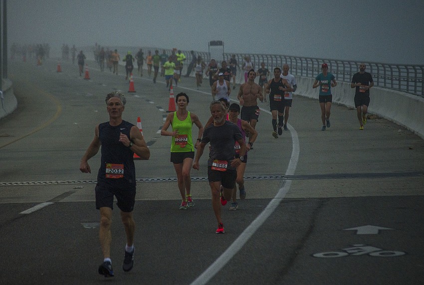 Runners run across the Ringling Bridge.