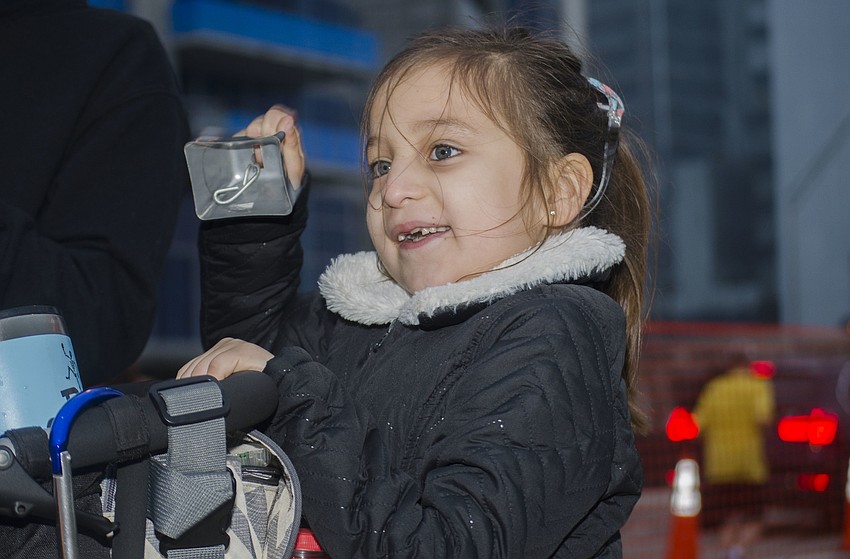 Belen Contreras rings a cowbell as her father runs