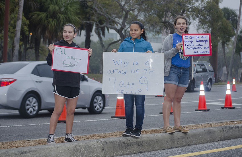 Camryn Derr, Chasity Green and Taylor Derr cheer on runners of the Sarasota Half Marathon.