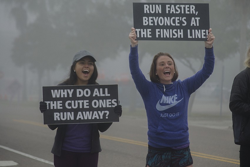 Jessica Amaya and Blair Gladding cheer on runners on the final turn of the Sarasota Music Half Marathon.