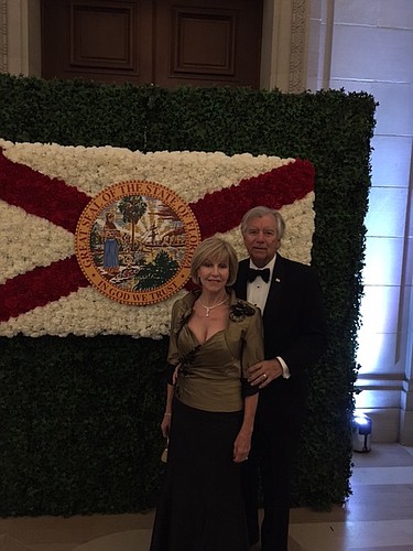 Susan and Tim Clarke stand with an image of the state flag of Florida before entering the Florida Sunshine Ball. Courtesy photo.