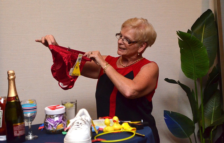 Peggy White held up props for each of the numbers called out. “Naughty 40” warranted a pair of red, lacy underwear.