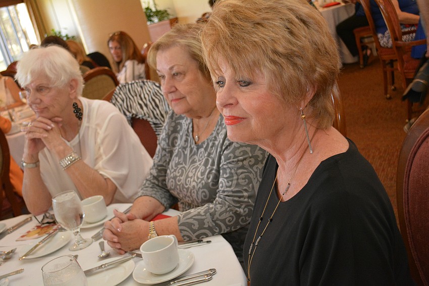 Lynn Thompson, front, listens to the fashion show introductions. Behind her are Marilyn Trescone, center, and Caroline Magda, left.