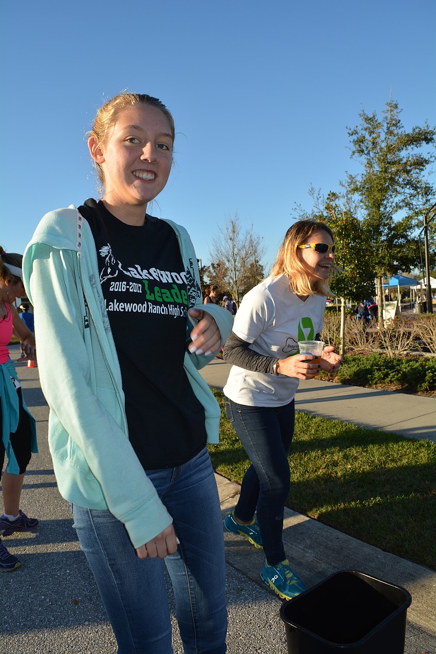 Lakewood Ranch High School'  s Courtney Yost takes timing bands off runners as they finish the run.