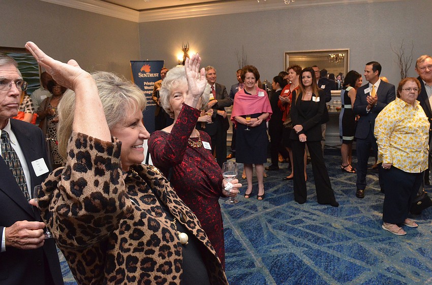 Margarete Van Antwerpen and Mary-Lou Mourton raise their hands to be recognized as Mike Uselton asks every member of the event committee to identify themselves.