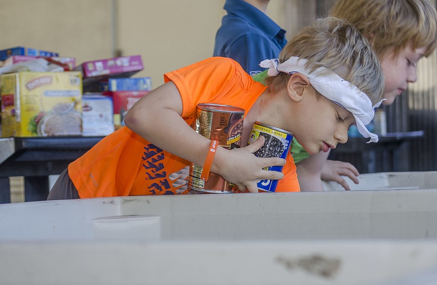 Zachary Kurnov sorts cans at All Faith’s Food Bank.