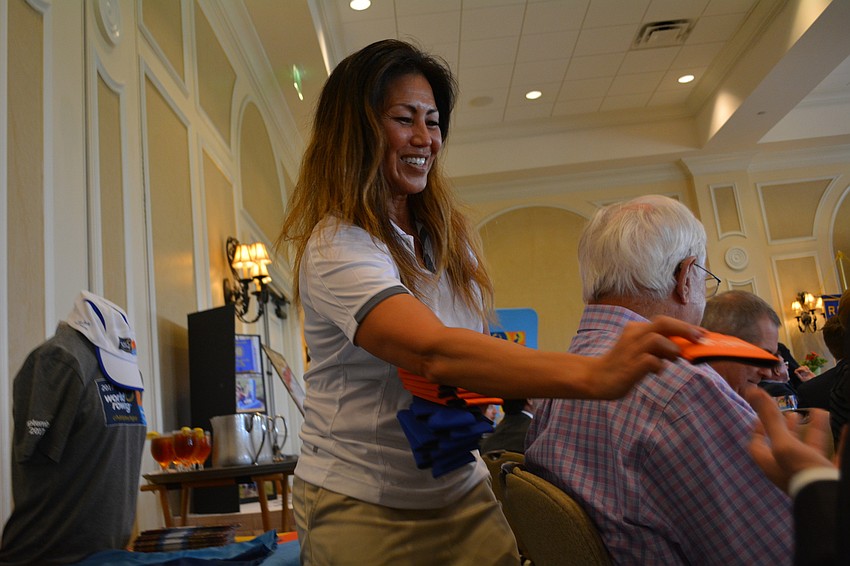 World Rowing Championship marketing and communication director Shelley Taniguchi hands out rowing championship cup sleeve.