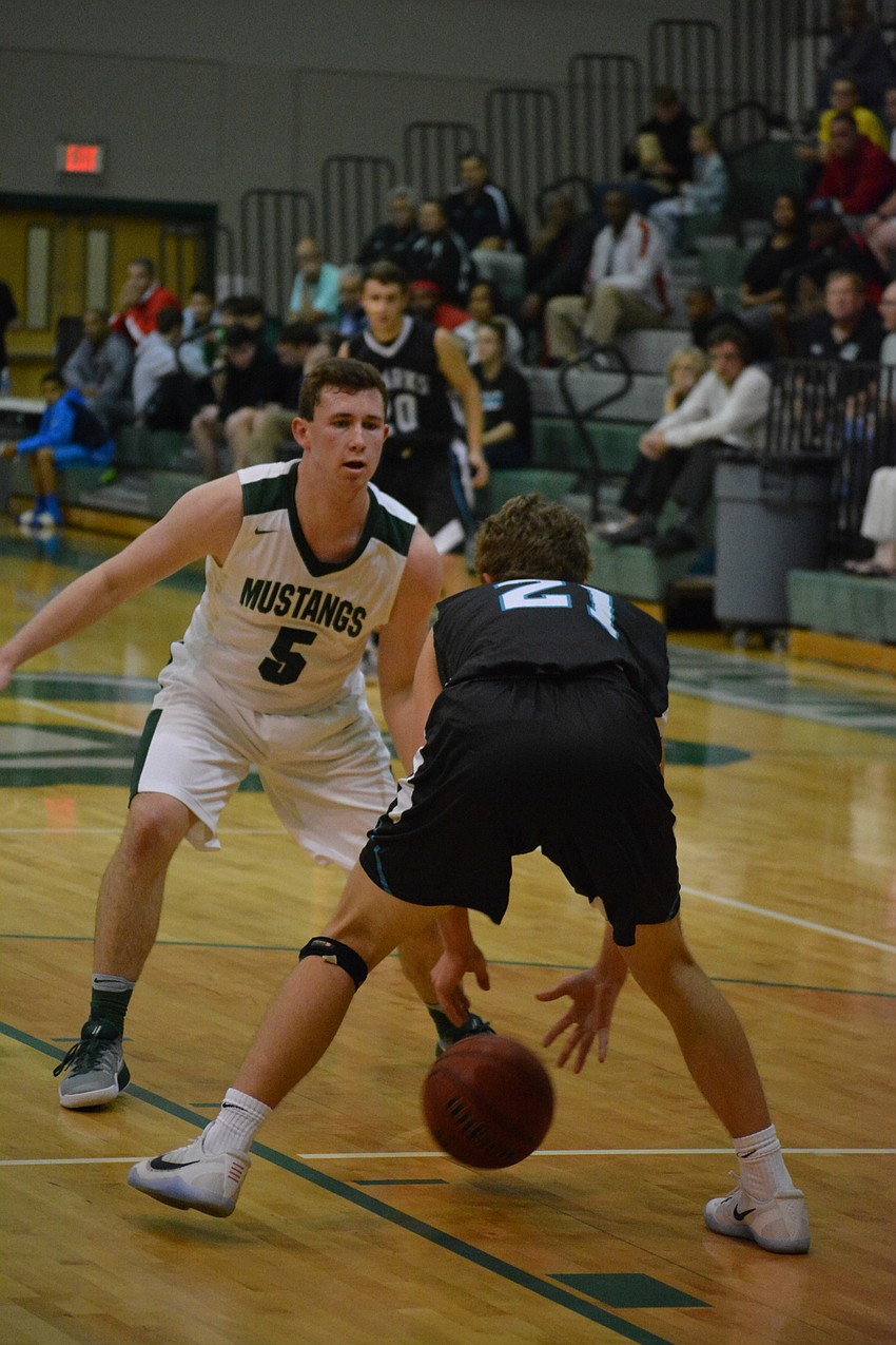 Sam Hester closely guards a Gulf Coast player.
