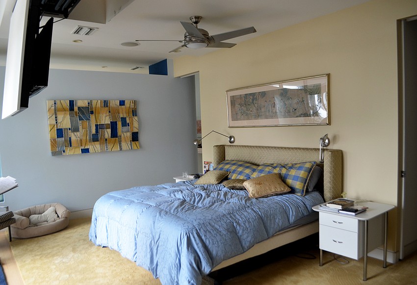 The master bedroom is complete with a television hung from the ceiling.