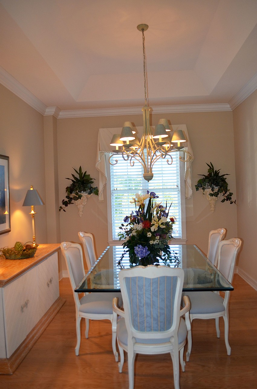 The dining room has simple colors, but the flowers on the table serve as the main focal point.