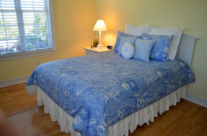 Blue bedding contrasts against the light yellows in a guest bedroom.