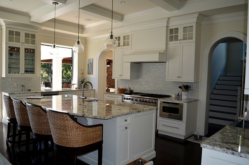 The kitchen is adjacent to the living room and features a small window and counter that face out to the pool deck.