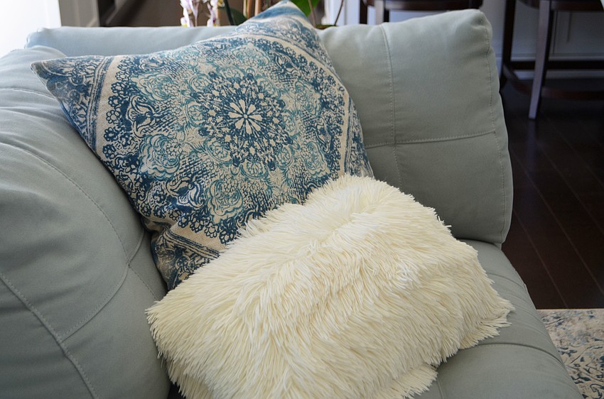 Blue and white accents, like these pillows, add to the sand and sea theme.