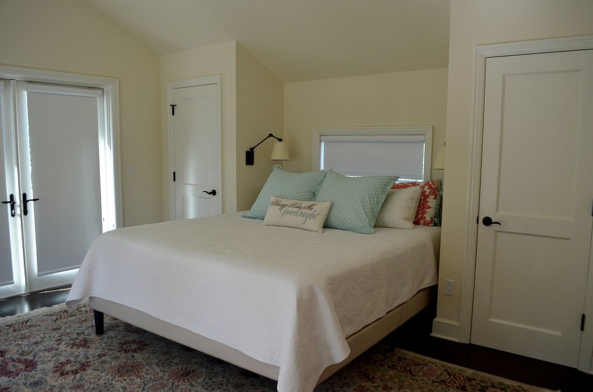 Another guest bedroom is simply decorated with colorful accent pillows and a rug.