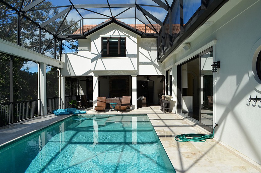The pool deck is complete with a grill, television, sitting area and counter island facing into the kitchen.