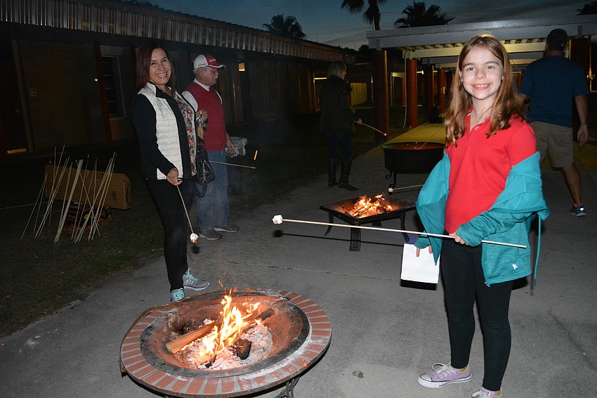 Karina Rodriguez, a visitor from Peru, roasts marshmallows with friend Arianna Dulaney, 10.