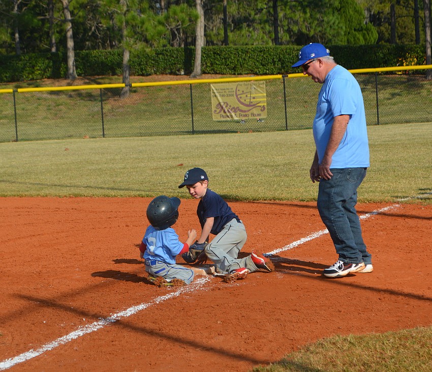 The Mariners'    Logan Yates puts the tag on the Royals'    Andrew Lazaris as they land in a heap at first.