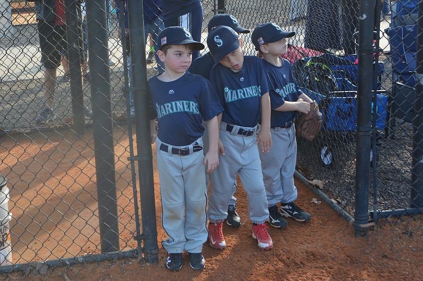 Logan Yates, Ethan Banks and Connor Alfano of the Mariners have fun passing time while waiting for their chance to hit.